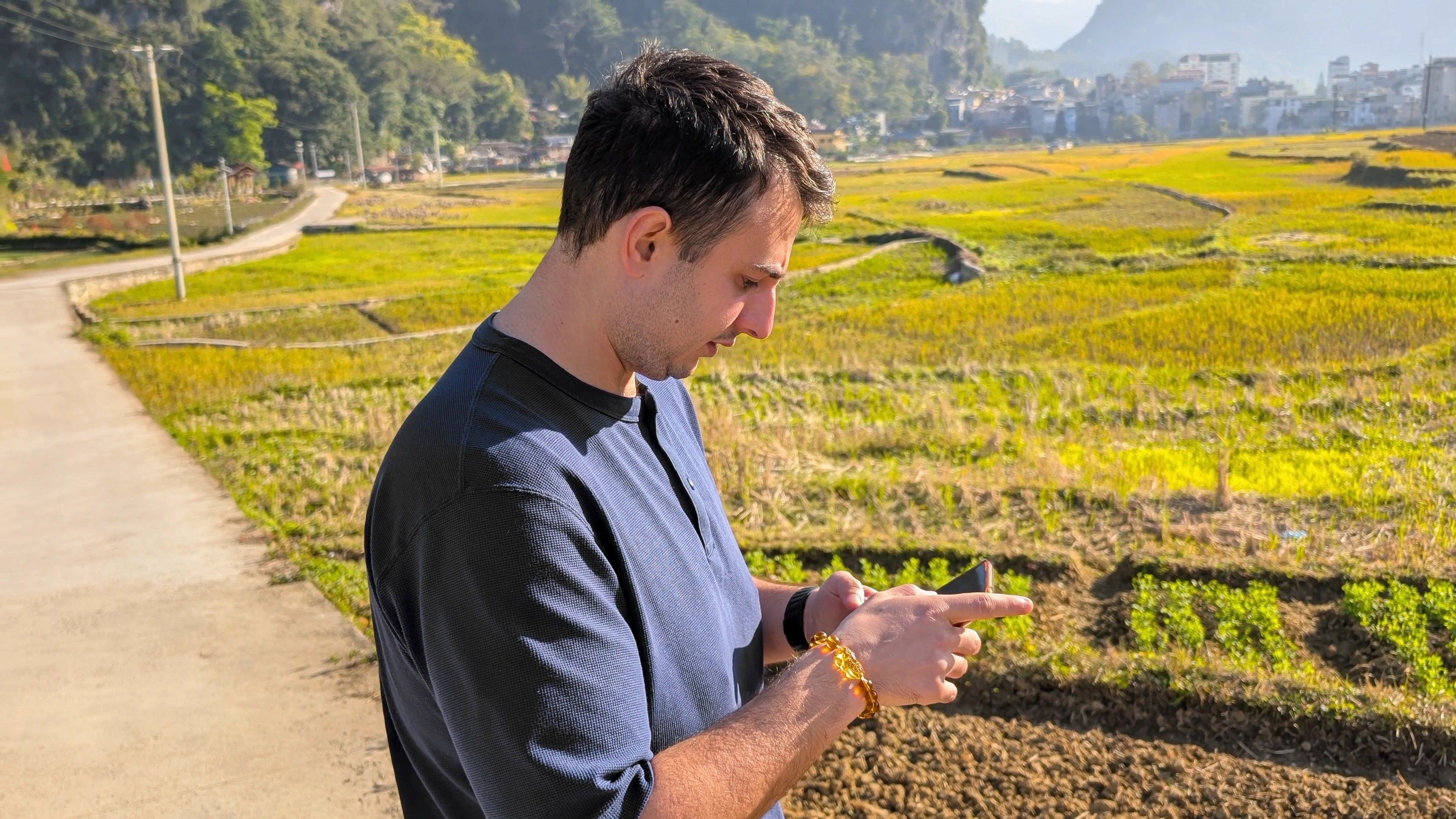 Liam standing in a rice field in Vietnam using his phone data