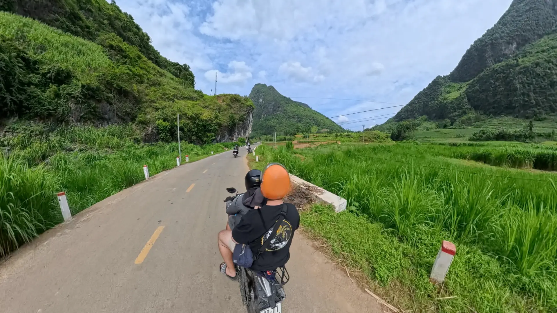 Motorbike POV riding through a misty green mountain valley on the Ha Giang Loop, June 2026