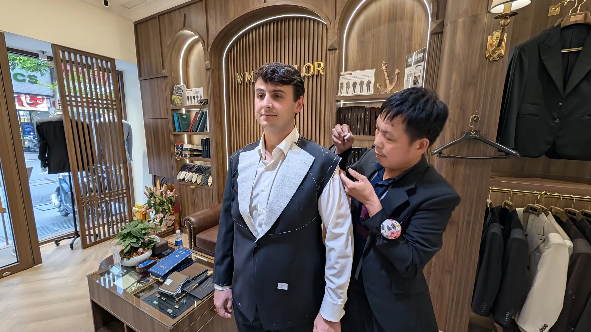 A VMan tailor pinning the shoulder on Liam's rough fitting jacket