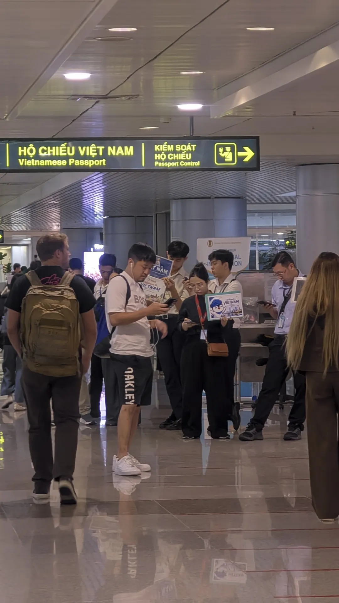 Fast track staff holding name signs before passport control at Ho Chi Minh City's Tan Son Nhat airport