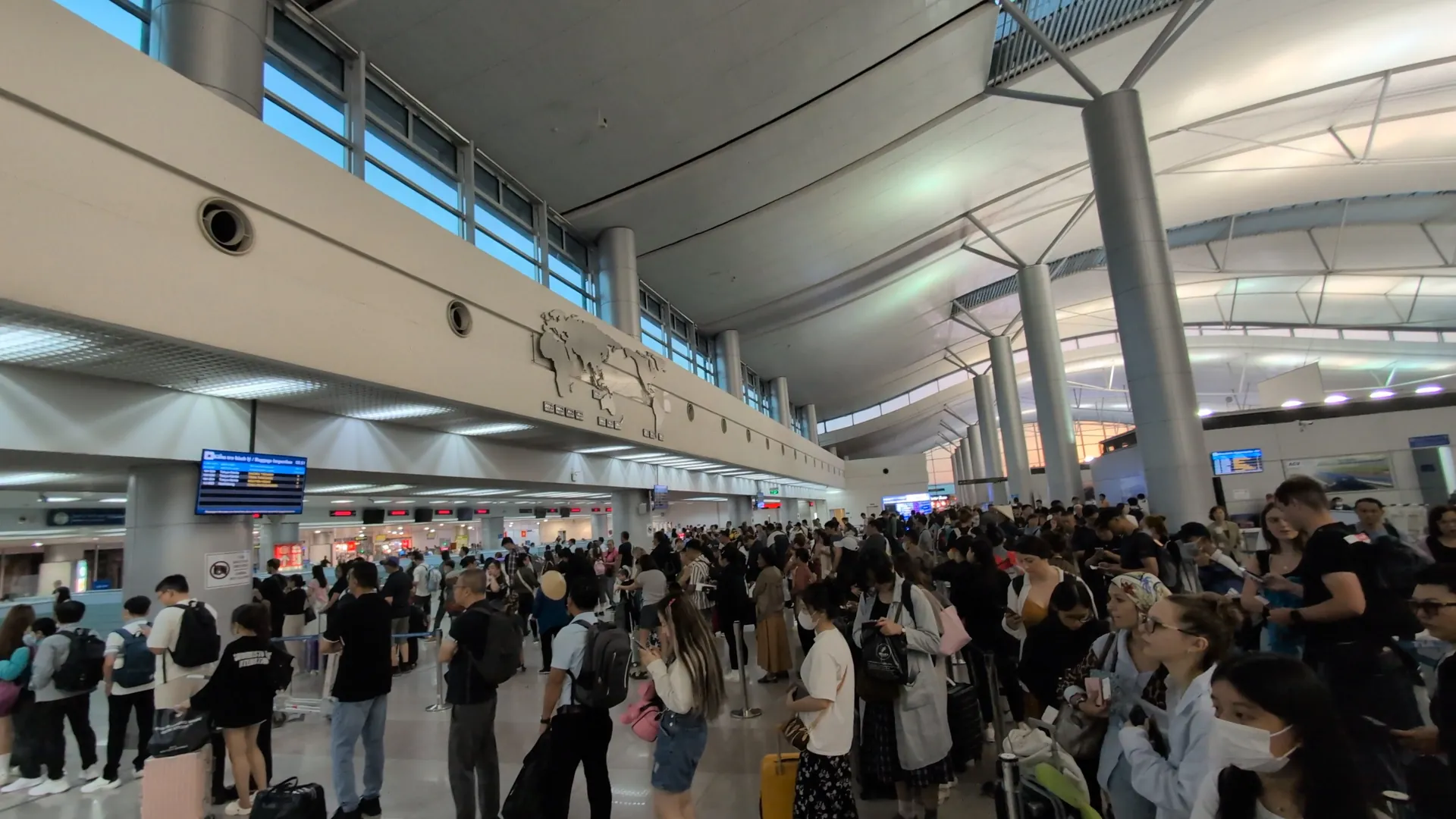 A huge crowd of travellers queuing in the arrivals immigration hall at a Vietnam airport