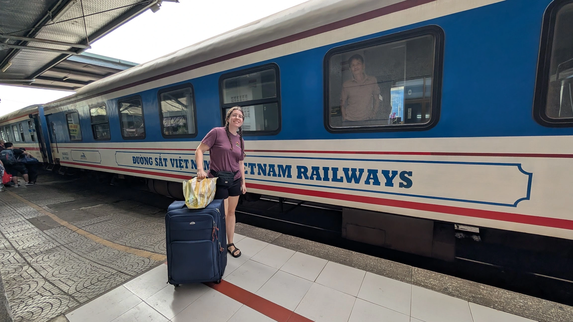 Sarah with suitcase outside Vietnam train